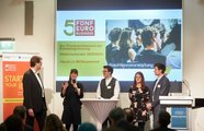Fünf Menschen stehen auf der Bühne und halten eine Präsentation