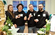 Vier Menschen posieren an ihrem Stand für die Kamera