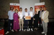 Eine Gruppe von Menschen und ein Jugendlicher in der Mitte, der ein Zertifikat hochhält, posieren für ein Bild