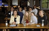 Mehrere Leute sitzen an Tischen und lachen