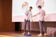 Zwei Studierende präsentieren ihr Produkt auf der Bühne