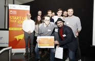 Eine Gruppe von Menschen und ein Jugendlicher in der Mitte, der ein Zertifikat hochhält