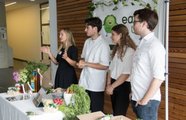 Vier Menschen stehen hinter ihrem Ausstellungstisch und präsentieren ihr Produkt