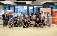 Eine große Gruppe Menschen posiert für ein Foto und hält ein Zertifikat in der Hand