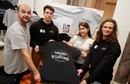 Vier Studierende halten ihr Produkt in die Kamera