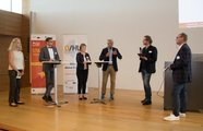 Eine Gruppe Menschen steht im Halbkreis und unterhält sich