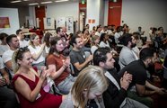 Ein klatschendes und lachendes Publikum, welches in Richtung Bühne schaut