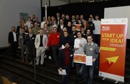 Eine große Gruppe, die in die Kamera lächelt und mit Zertifikat posiert