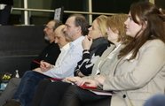Erwachsene, die in einer Reihe sitzen und zur Bühne schauen