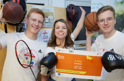 ein drittplatziertes Start-up-Team steht mit Boxhandschuhen und Bällen nebeneinander und halten einen Scheck über 400 Euro in der Hand.